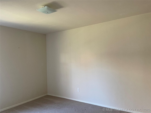 carpeted spare room with baseboards