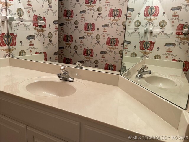 bathroom with wallpapered walls and vanity