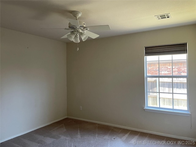 carpeted empty room featuring ceiling fan, visible vents, and baseboards