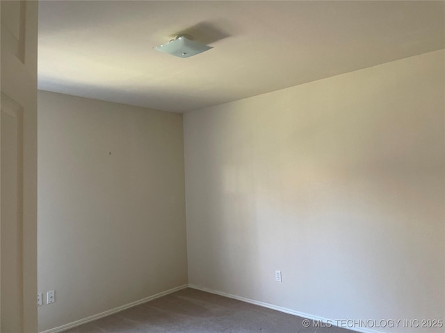 empty room featuring carpet floors and baseboards