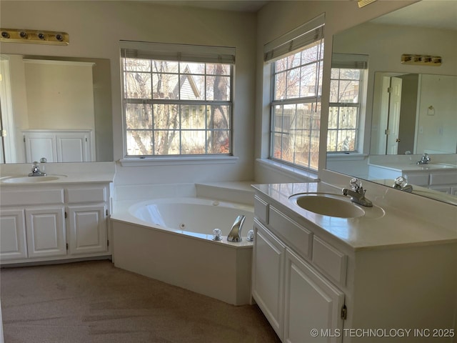 bathroom featuring a whirlpool tub, two vanities, and a sink