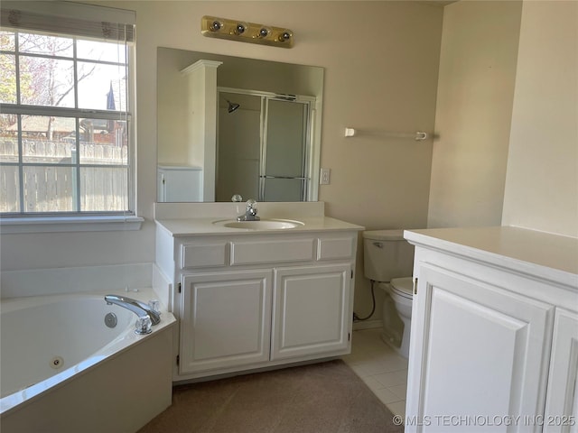 full bath with tile patterned flooring, toilet, vanity, a shower stall, and a whirlpool tub