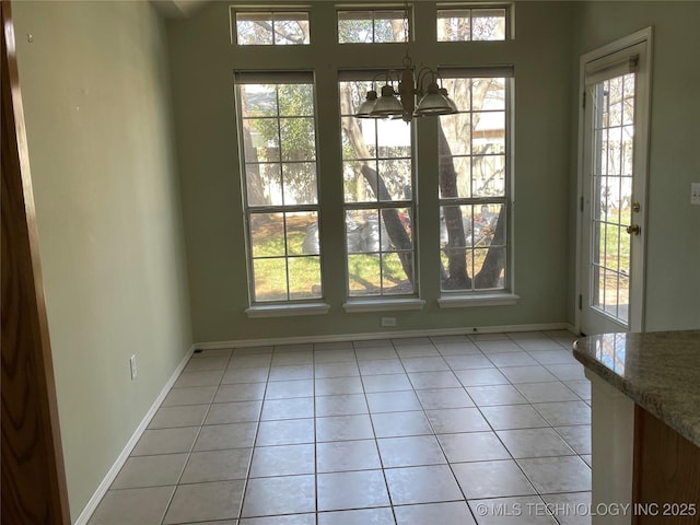 interior space featuring light tile patterned floors, baseboards, and a wealth of natural light