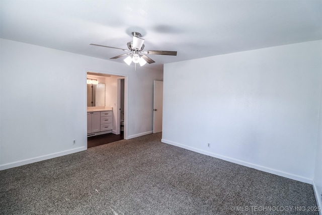 unfurnished bedroom featuring connected bathroom, dark carpet, baseboards, and a ceiling fan