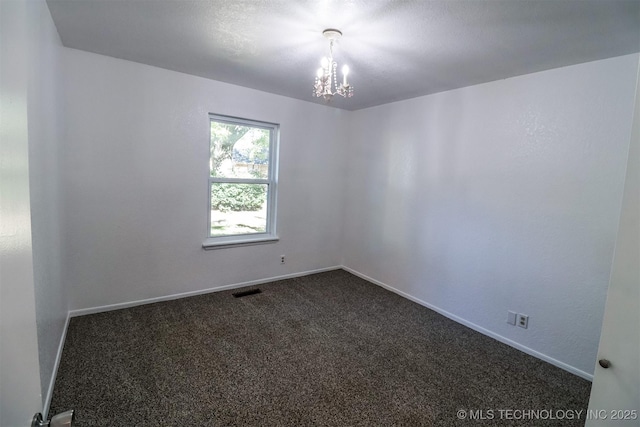 unfurnished room with a chandelier, dark carpet, visible vents, and baseboards