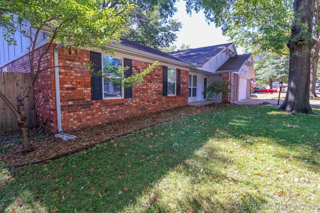 view of property exterior with brick siding, a lawn, an attached garage, and board and batten siding