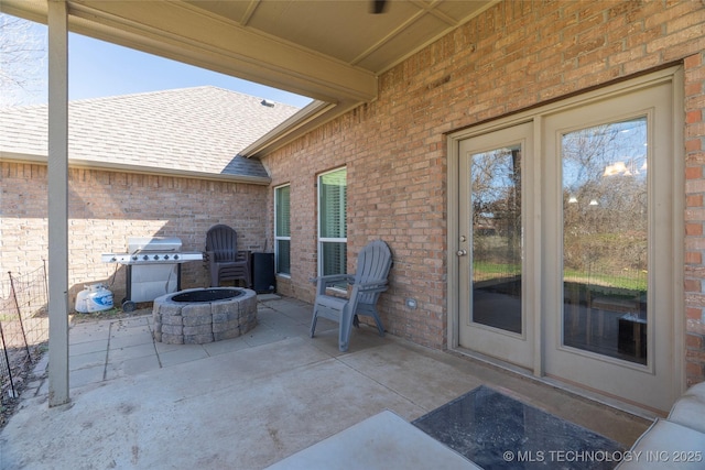 view of patio with area for grilling and a fire pit