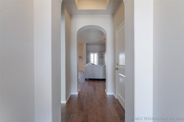 11923 E 105th Ct N, Owasso, OK 74055 - hall featuring arched walkways, baseboards, and dark wood finished floors