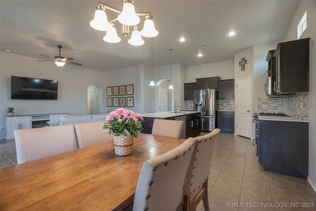 dining room with visible vents, ceiling fan with notable chandelier, recessed lighting, light tile patterned flooring, and arched walkways