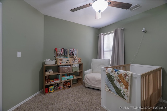 carpeted bedroom with visible vents, ceiling fan, baseboards, and a nursery area