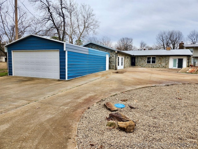 view of front of property featuring stone siding and a garage