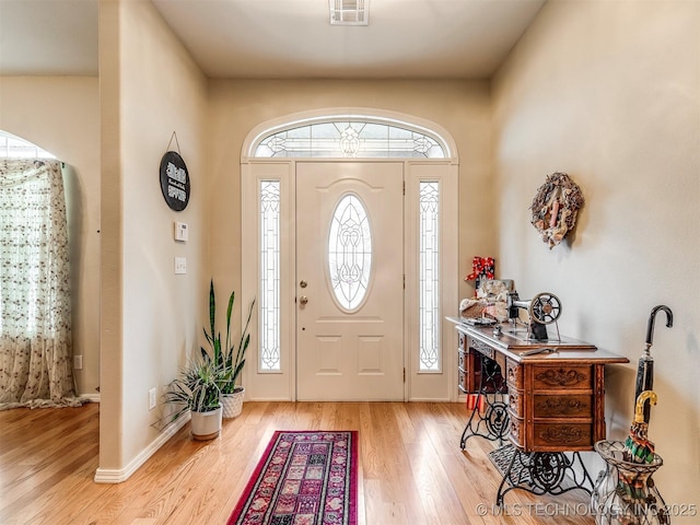 foyer with light wood-style floors, baseboards, visible vents, and a wealth of natural light