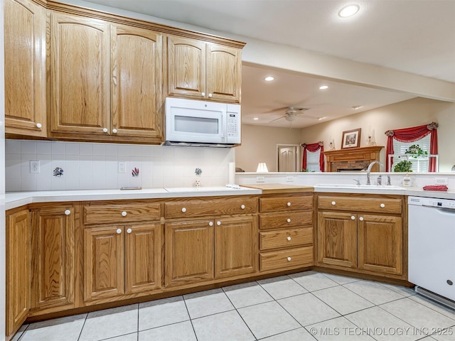 kitchen with ceiling fan, white appliances, a sink, and tasteful backsplash