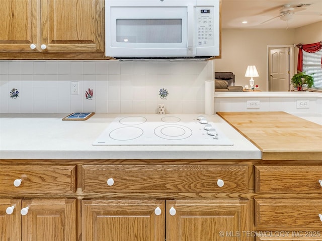 kitchen with ceiling fan, white appliances, light countertops, decorative backsplash, and brown cabinets