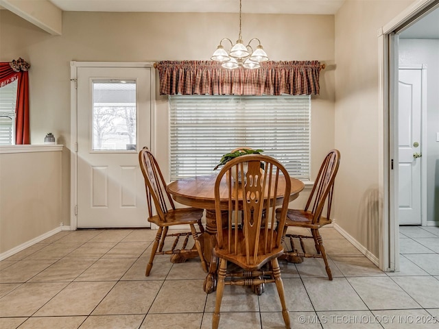 dining space featuring a notable chandelier, baseboards, and light tile patterned floors