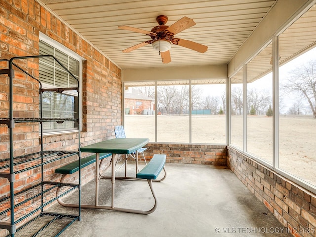 unfurnished sunroom with ceiling fan