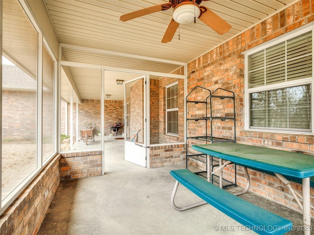 unfurnished sunroom featuring ceiling fan