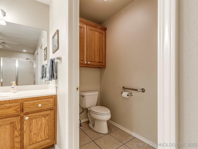 bathroom with toilet, a ceiling fan, a stall shower, vanity, and tile patterned floors