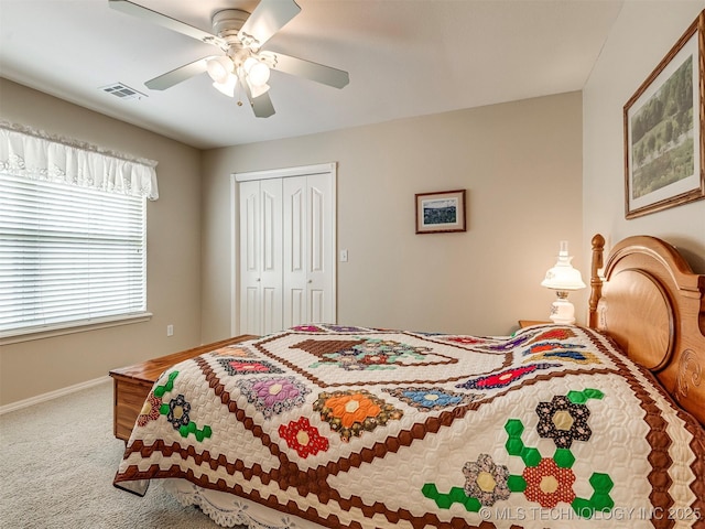 carpeted bedroom featuring a ceiling fan, a closet, visible vents, and baseboards