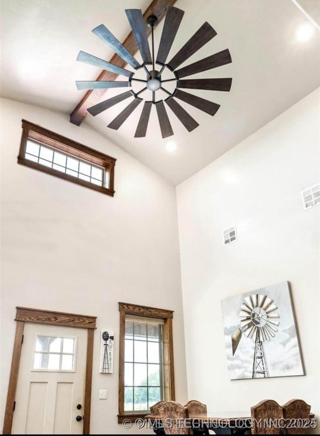 interior details featuring a ceiling fan, visible vents, and beamed ceiling