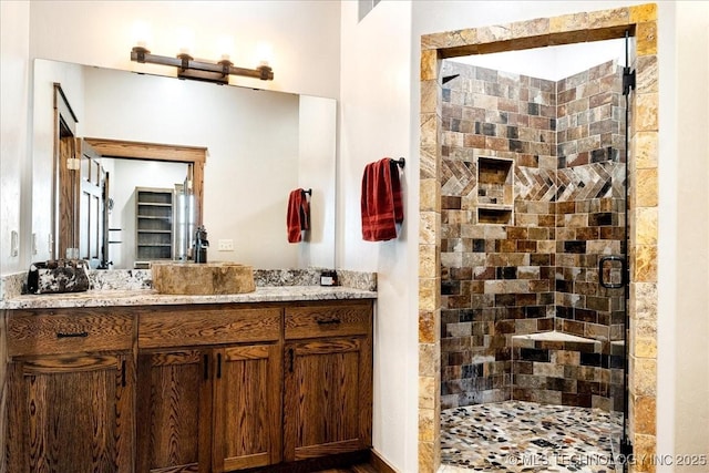 bathroom featuring a shower stall and vanity