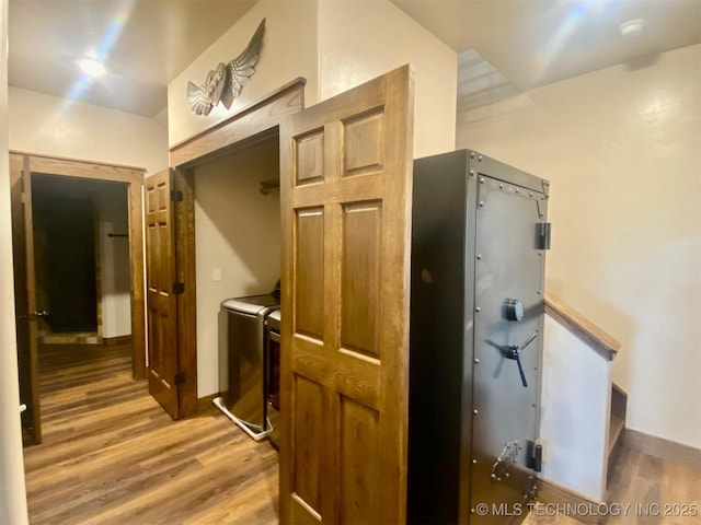 kitchen with baseboards, washing machine and clothes dryer, and light wood finished floors