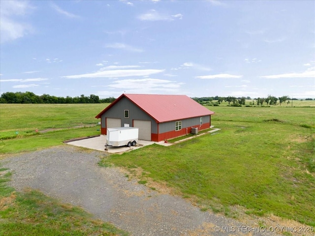 exterior space with an outbuilding, an outdoor structure, a detached garage, a front yard, and gravel driveway