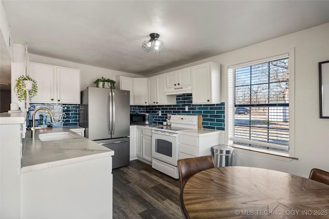 kitchen with stainless steel appliances, a sink, white cabinetry, and under cabinet range hood