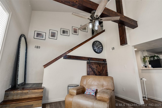 sitting room featuring wood finished floors, visible vents, baseboards, a ceiling fan, and beam ceiling