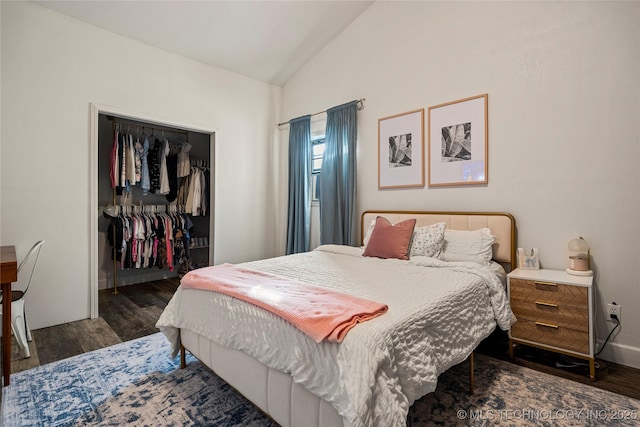 bedroom featuring a closet, vaulted ceiling, a spacious closet, and wood finished floors