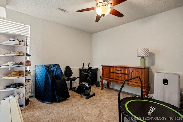 interior space featuring a textured ceiling, a textured wall, and carpet flooring