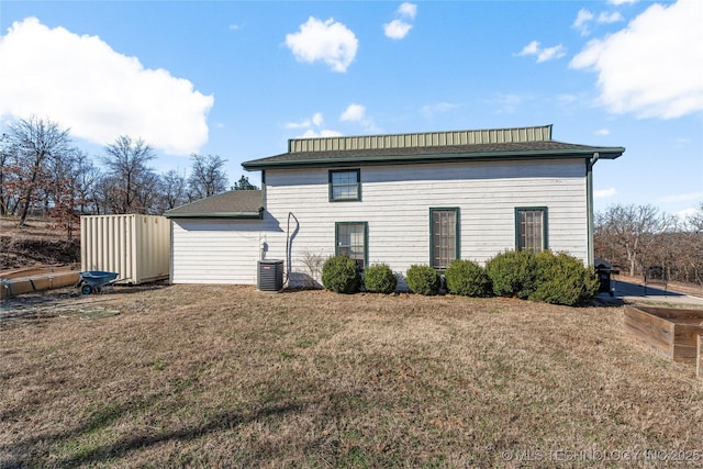 back of house featuring a yard and central air condition unit