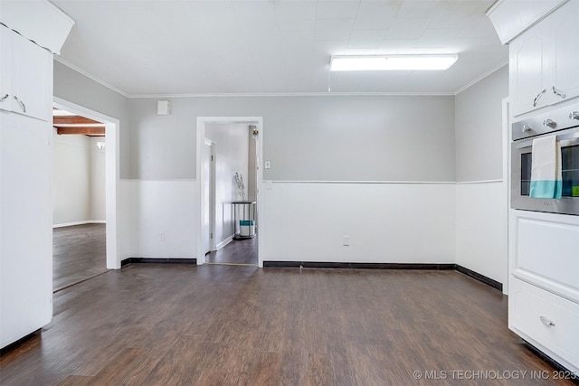 unfurnished room with dark wood-style floors, baseboards, and crown molding