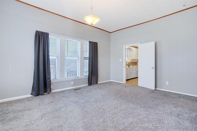 empty room with carpet, visible vents, and baseboards