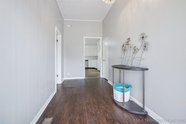 hall featuring wood finished floors, visible vents, and baseboards