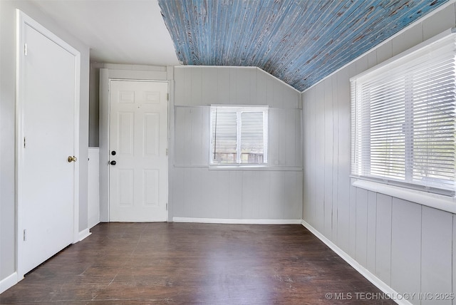 unfurnished room featuring lofted ceiling, wood ceiling, plenty of natural light, and wood finished floors