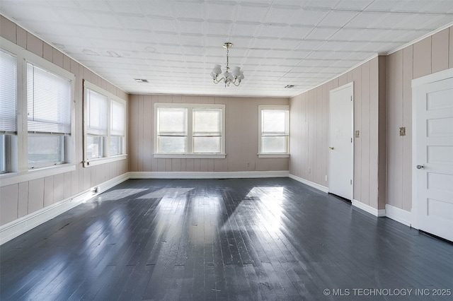 interior space featuring baseboards, dark wood-style flooring, and a notable chandelier