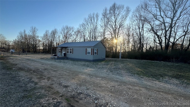 view of front of house featuring metal roof and dirt driveway