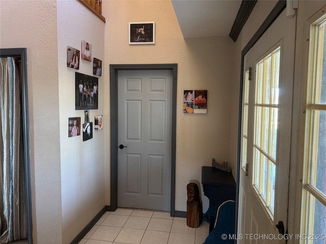 entryway with light tile patterned floors and baseboards