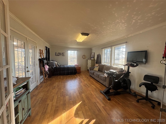 unfurnished living room featuring ornamental molding, french doors, and light wood finished floors