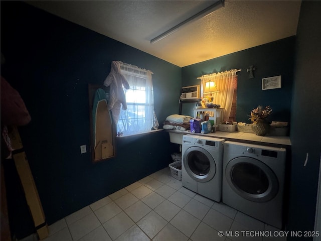 washroom featuring a textured ceiling, laundry area, separate washer and dryer, and tile patterned flooring