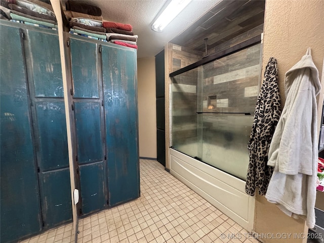 bathroom featuring a combined bath / shower with rainfall shower, a textured ceiling, and tile patterned floors