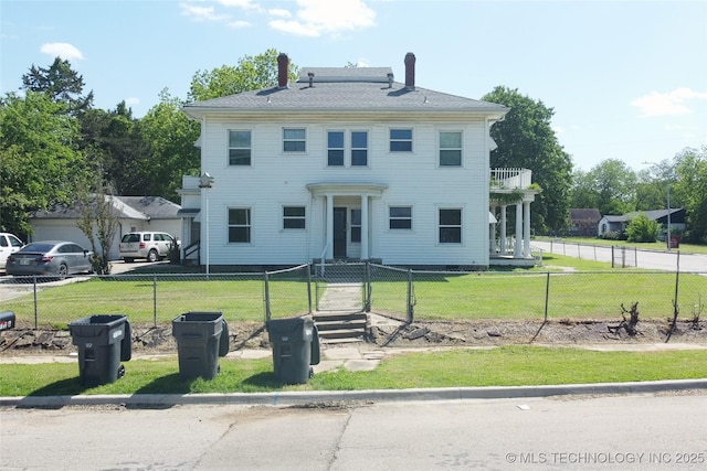 view of front of house featuring a balcony, a fenced front yard, and a front yard