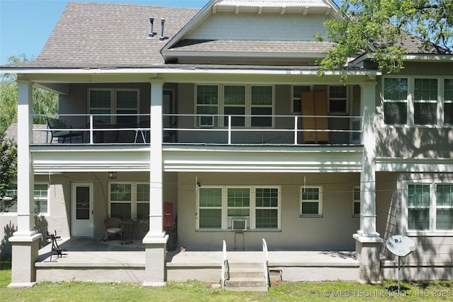 back of property featuring a porch, roof with shingles, a balcony, and stucco siding