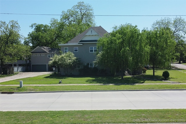 exterior space with a front yard, concrete driveway, and an attached garage