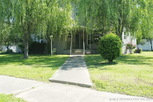 obstructed view of property with a front lawn and stucco siding