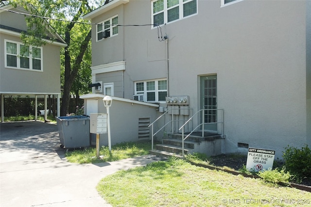 exterior space with driveway, a carport, and stucco siding