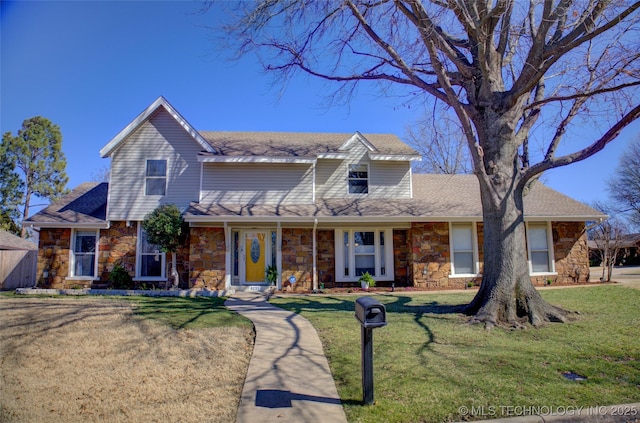 view of front of house featuring stone siding, a shingled roof, and a front yard