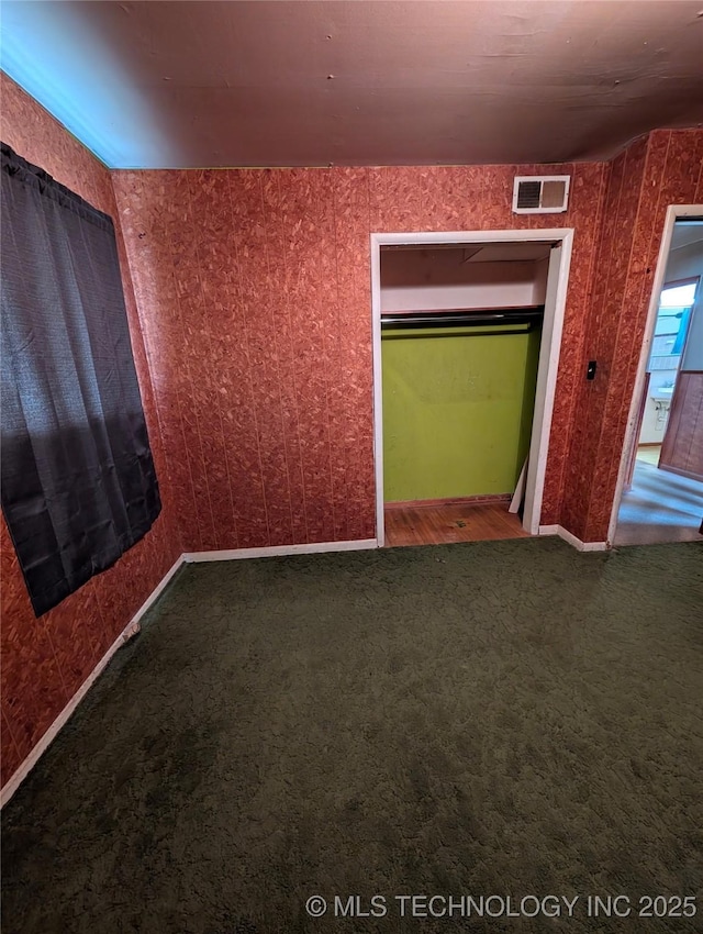 unfurnished bedroom featuring carpet and visible vents