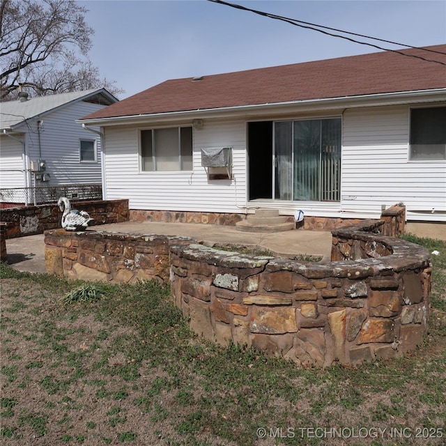 back of house with entry steps and a shingled roof